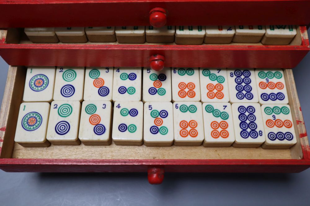 A Mah Jong set in red stained wood case